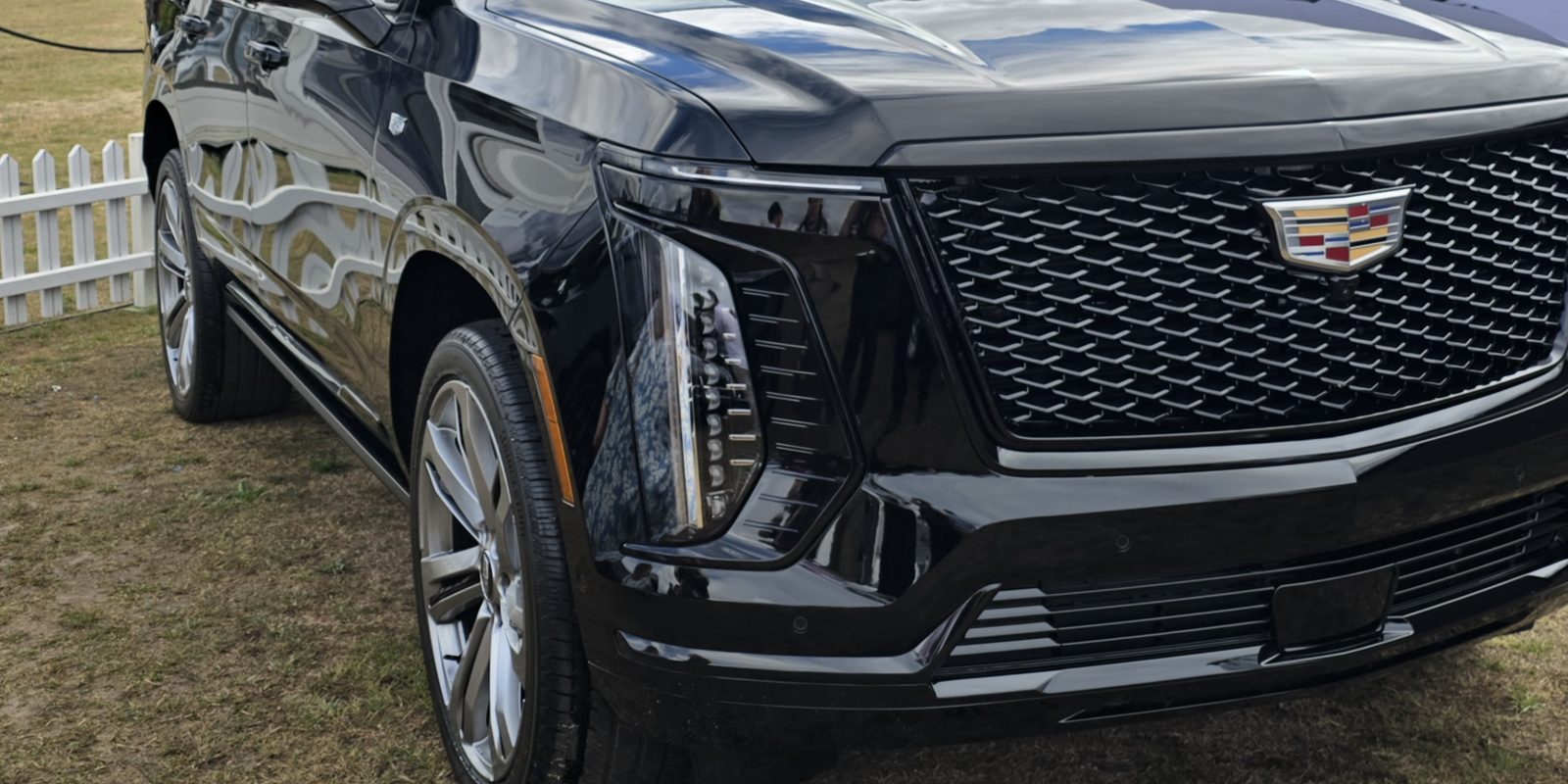Gloss black 2025 Cadillac Escalade Sport photographed close in at a three-quarter front angle