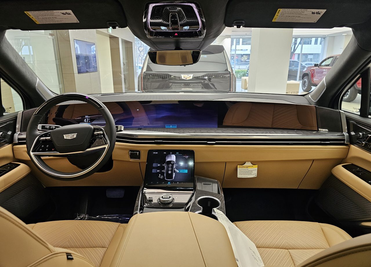 Executive SUV cabin with pale leather seating and a full-width dashboard display